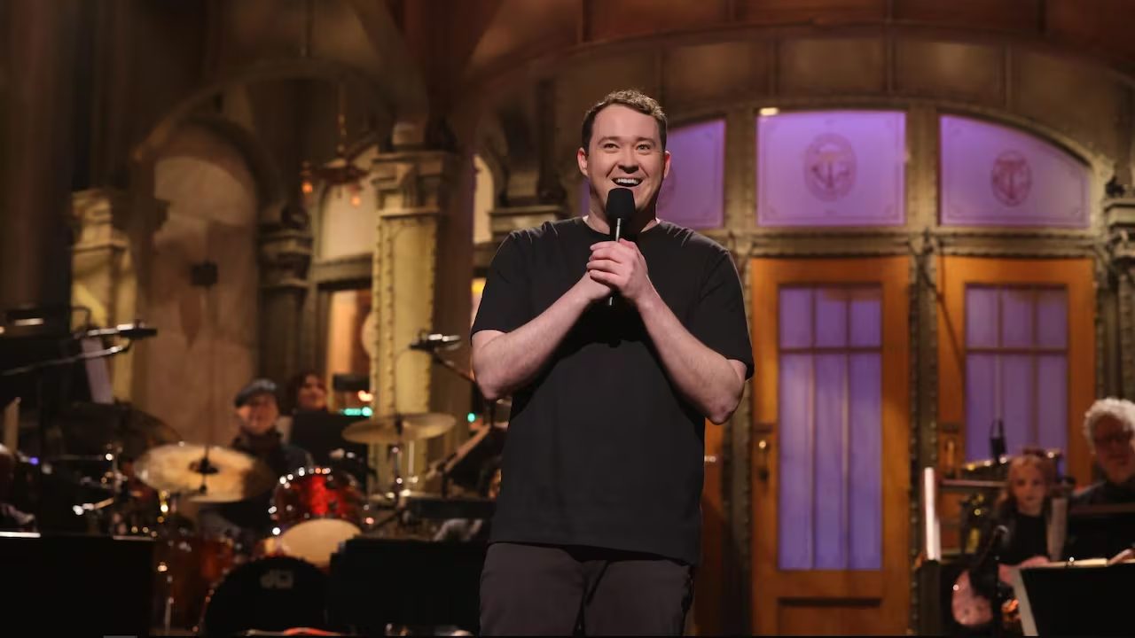 Comedian performing stand-up on stage with a microphone